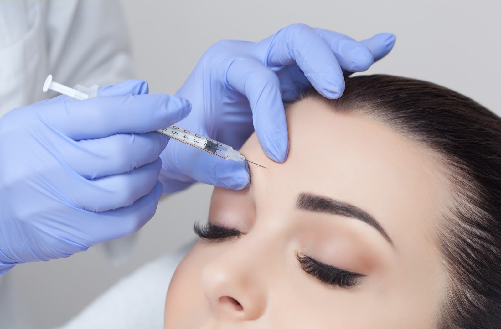 A woman receiving a Botox injection from a cosmetic physician