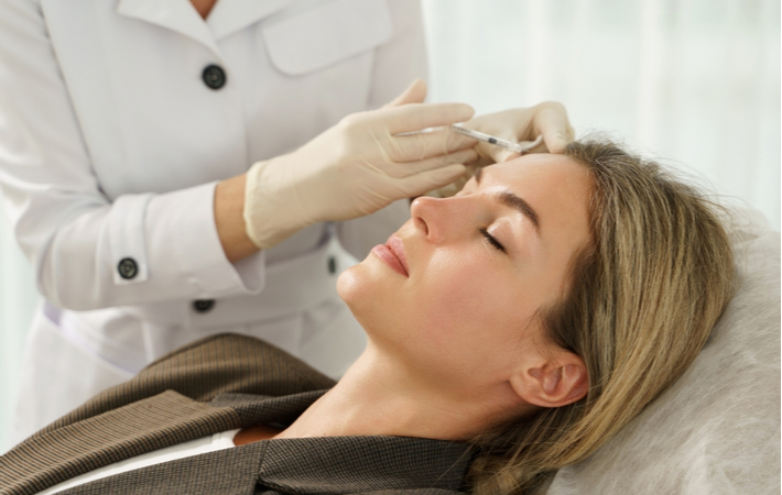 Young women receiving Dermal Fillers from professional at clinic