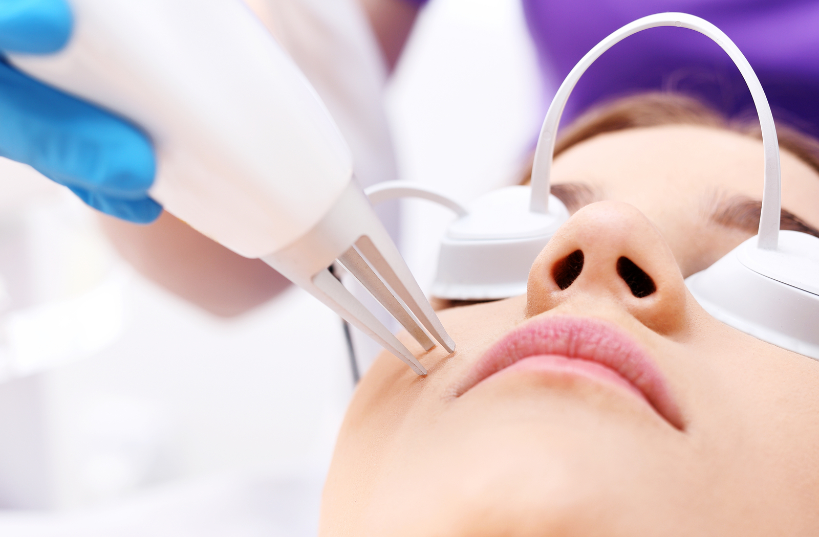 Close up of women receiving acne laser treatment at professional clinic
