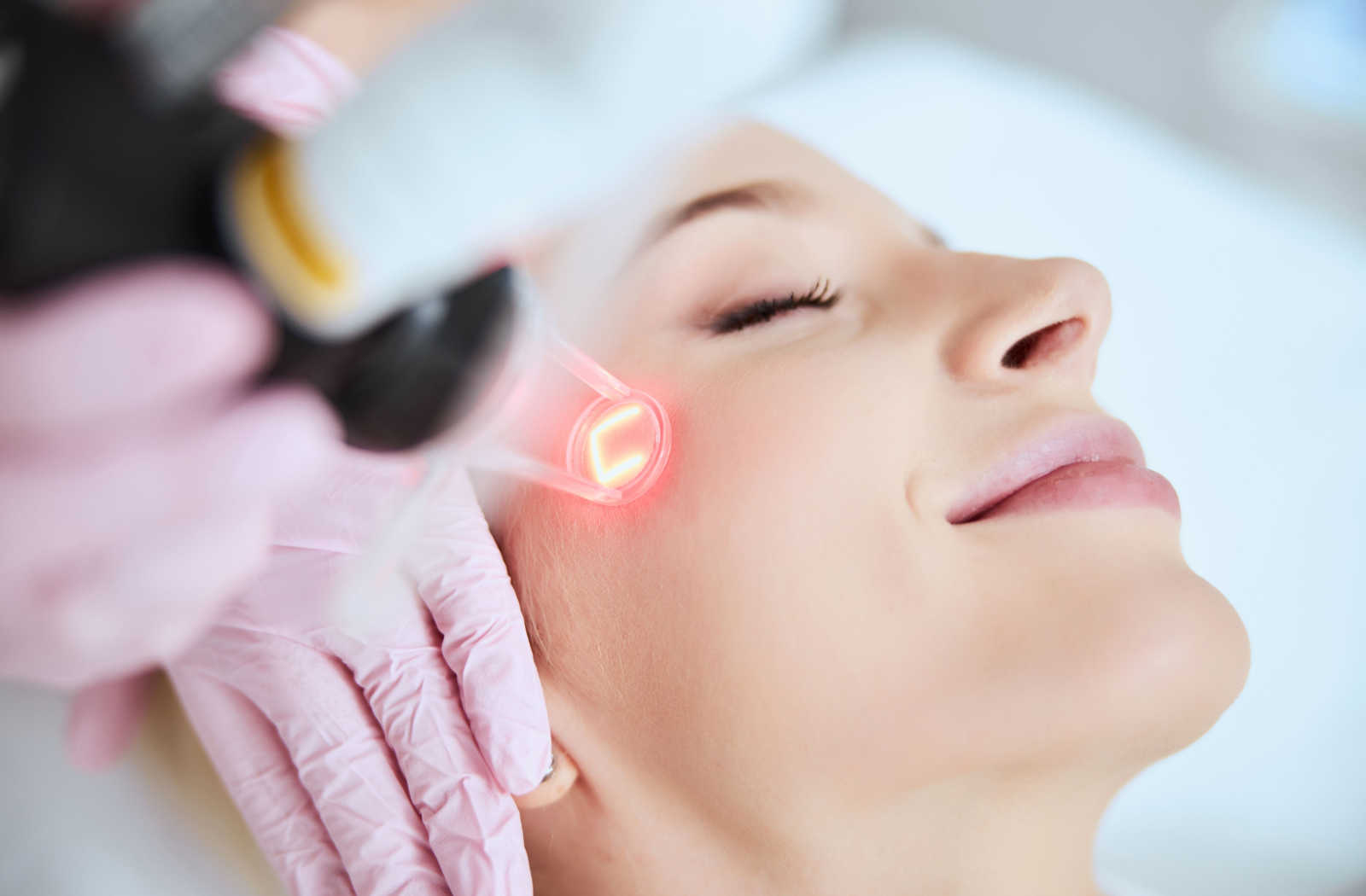 Young adult woman receives laser treatment.