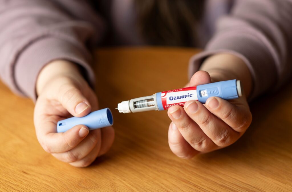 A woman holding an open ozempic syringe.