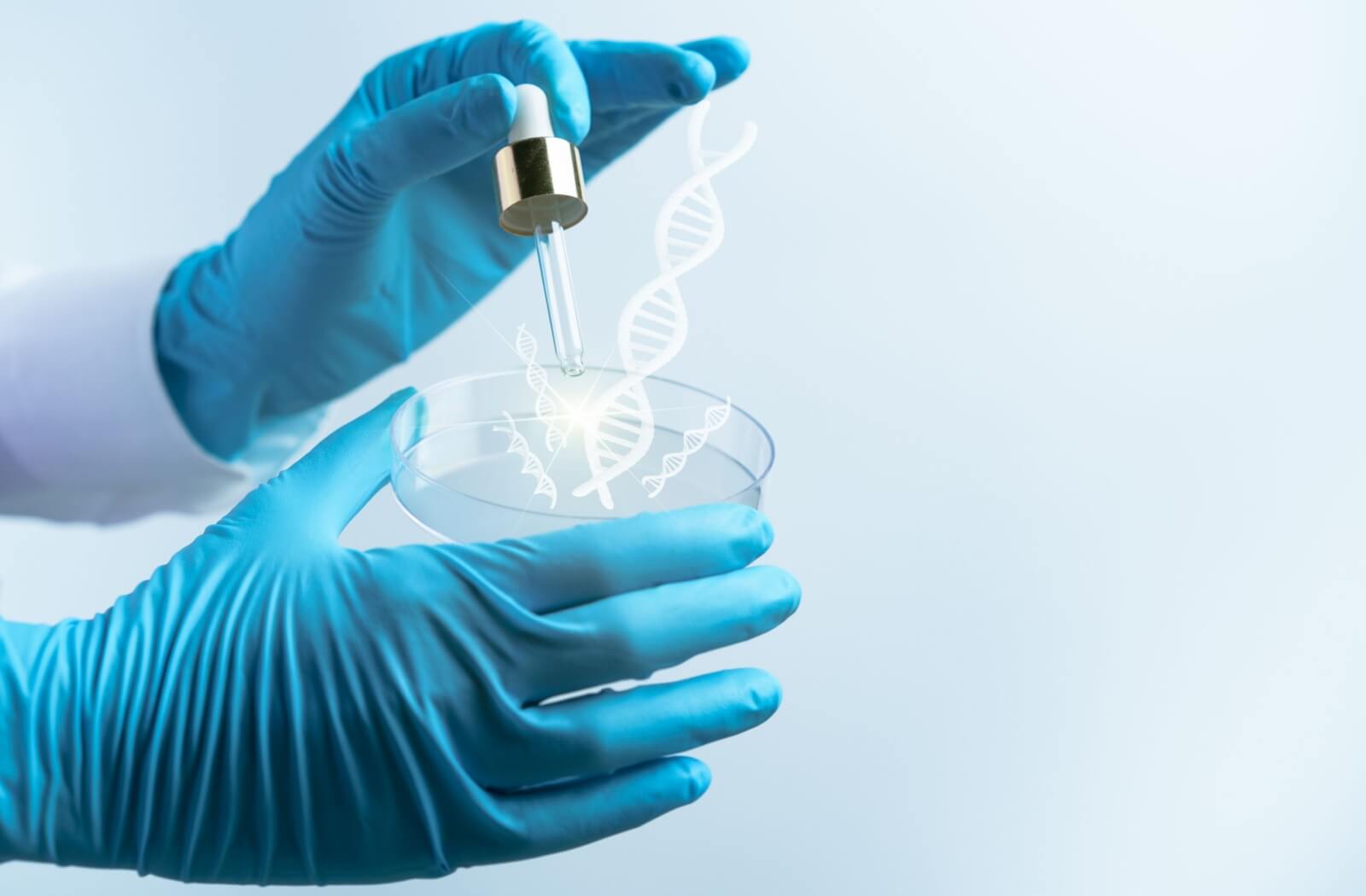 A person wearing a blue medical glove holding a 3D-printed model of DNA.