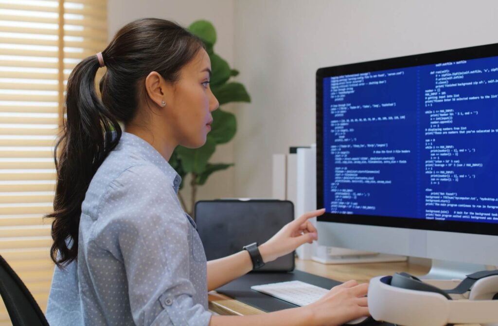 A medical professional sitting in front of a computer auditing their data security.