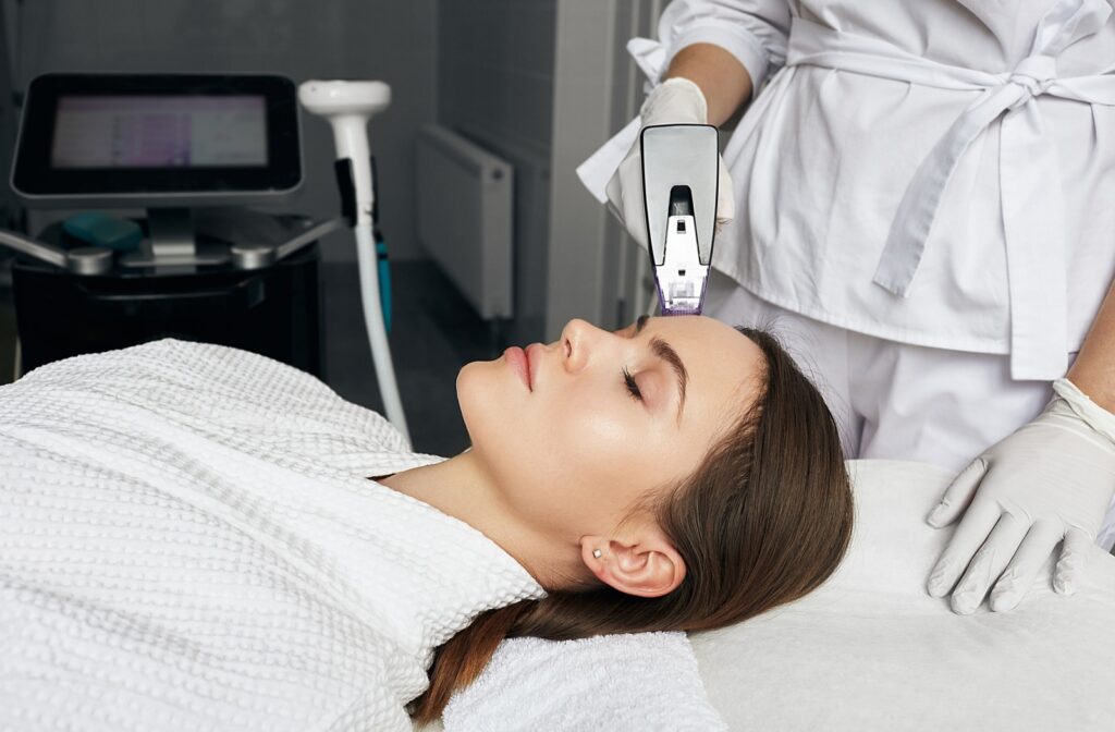 Patient receiving Morpheus8 treatment on forehead to stimulate collagen production.
