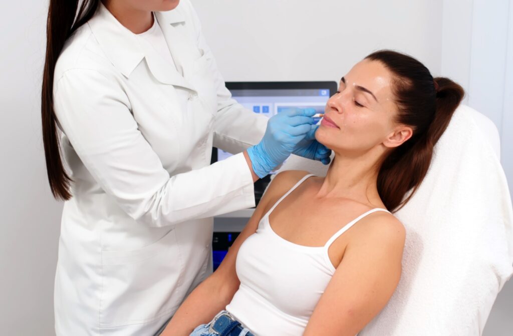 A practitioner carefully outlines the desired fullness of their client's upper lip during their initial consultation.